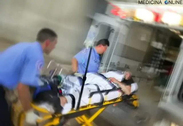Due paramedici portano paziente in barella in ambulanza