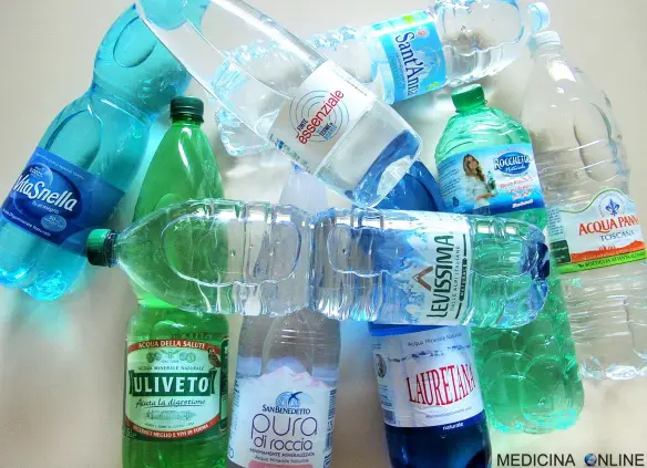 Varie bottiglie di plastica piene d'acqua di alcune marche famose